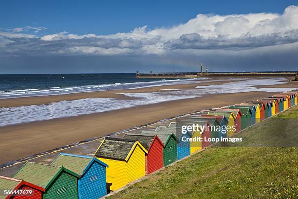 Colourful beach huts along West Cliff Beach in Whitby.