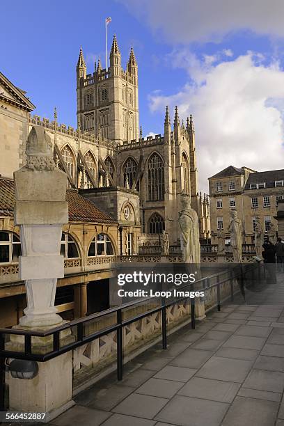 Roman statues around the Roman Baths with Bath Abbey in the background.