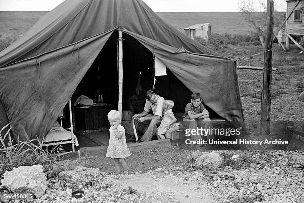 Migrant worker with his children living in a tent during the American Great Depression.