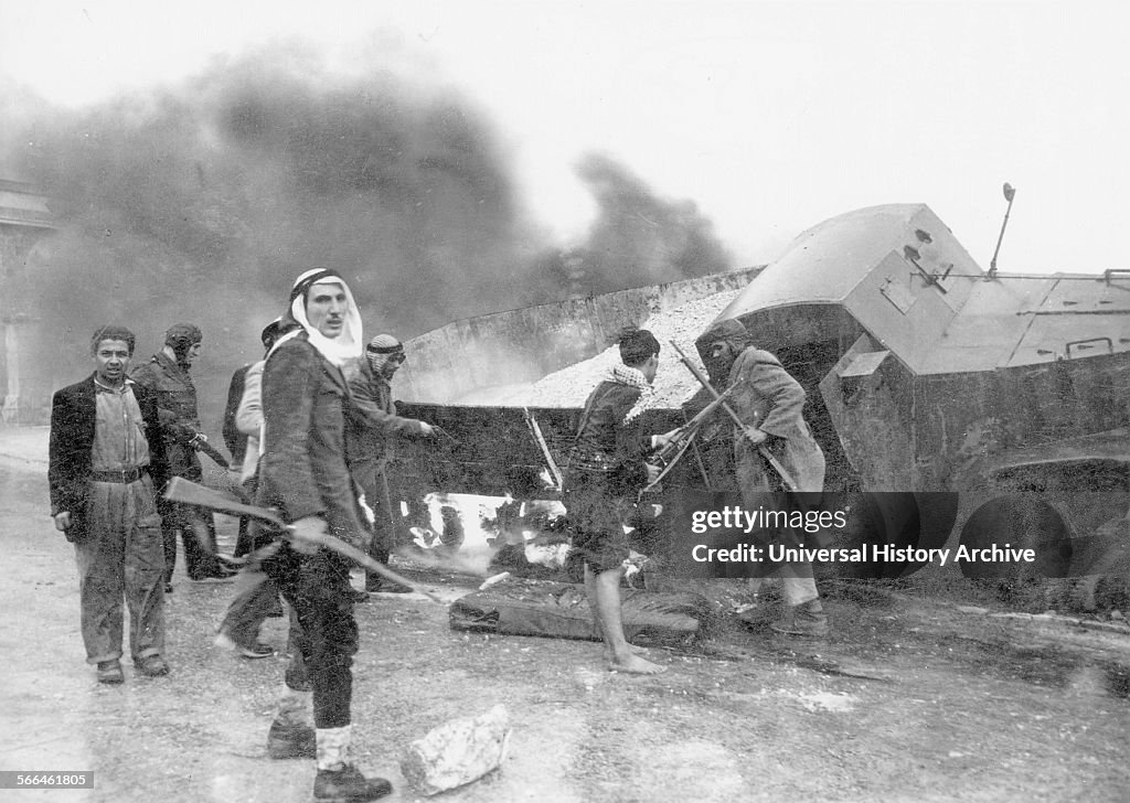 Palestinian irregulars near a burnt armoured Haganah supply truck.