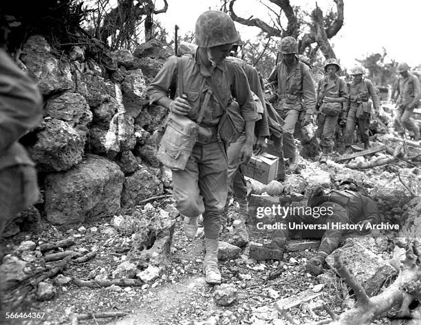Okinawa U.S. Marines pass a dead Japanese soldier in a destroyed village, during World War two 1945.
