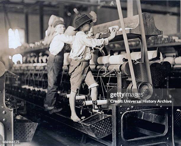 Child labour in the USA 1909. Bibb Mill No. 1 Many youngsters here. Some boys were so small they had to climb up on the spinning frame to mend the...