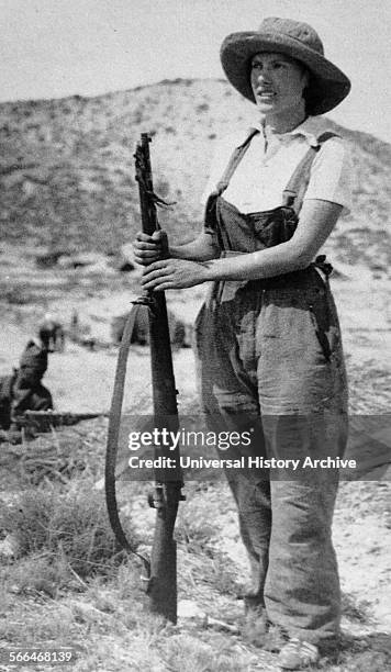 Republican woman civilian stands guard with a rifle during the Spanish Civil War.