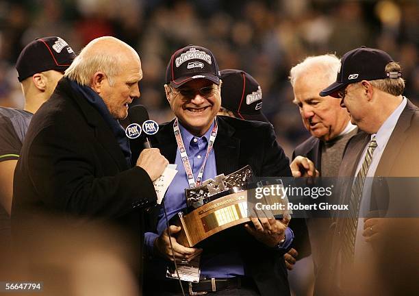 Seattle Seahawks owner Paul Allen speaks with television commentator Terry Bradshaw holds up the NFC Championship trophy following his team's victory...
