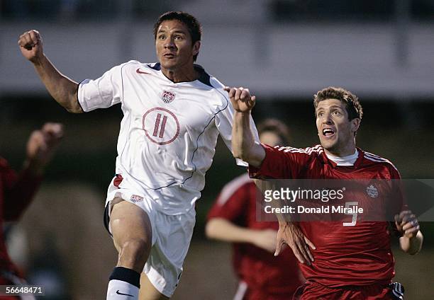 Brian Ching of the USA goes up against Marco Reda of Canada during the USA v Canada friendly soccer match on January 22, 2006 at Torero Stadium in...