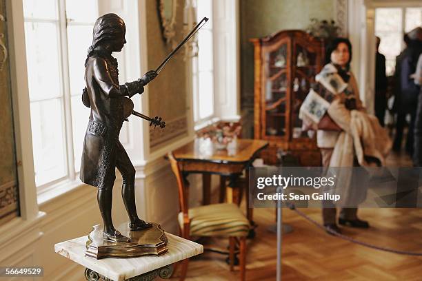 Visitor pauses to look at a small statue of Austrian composer Wolfgang Amadeus Mozart in the room where Mozart stayed and composed on several...