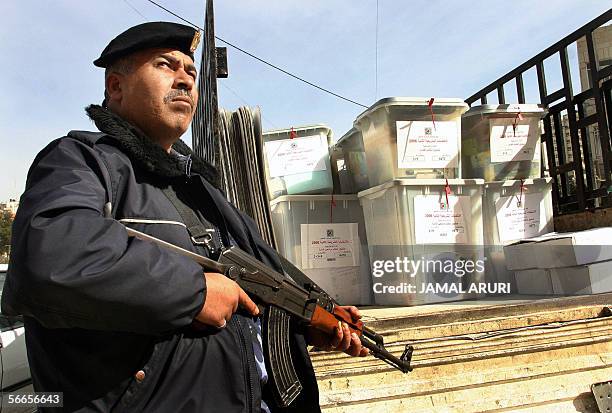 Palestinian security officers stands guard next to ballot boxes in preparation for tomorrow's legislative elections in the West Bank city of Ramallah...