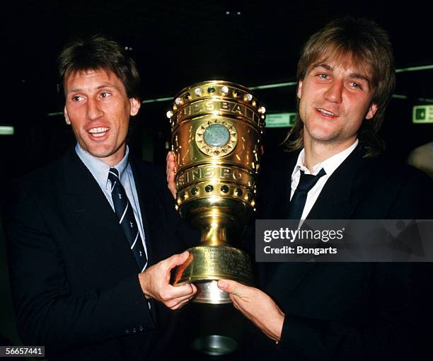 Manfred Kaltz and Dietmar Beiersdorfer of Hamburg celebrates with the trophy after winning the German Cup final match between Hamburger SV and...