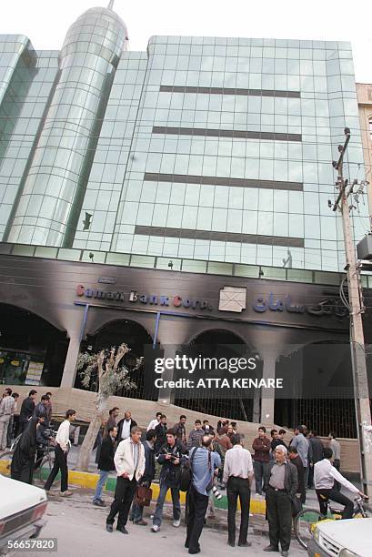 Onlookers gather outside the damaged Saman Bank at the scene of a double bomb attack in the southwestern Iranian city of Ahvaz, dominated by ethnic...