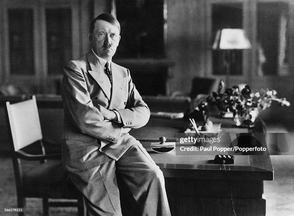 Nazi Leader Adolf Hitler Sitting On The Edge Of A Desk At His News nazi-leader-adolf-hitler-sitting-on-the-edge-of-a-desk-at-his-news