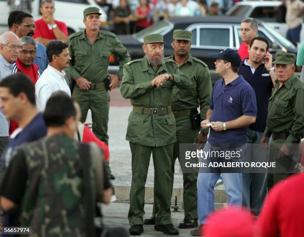 Rodeado de algunos de sus mas cercanos colaboradores y escoltas, el Presidente cubano Fidel Castro, verifica la hora en que debe comenzar el 24 de...