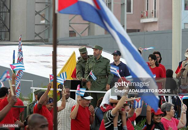 El Presidente cubano Fidel Castro observa a cubanos que marchan el 24 de Enero del 2006 por frente a la Oficina de Intereses de EE.UU en La Habana en...