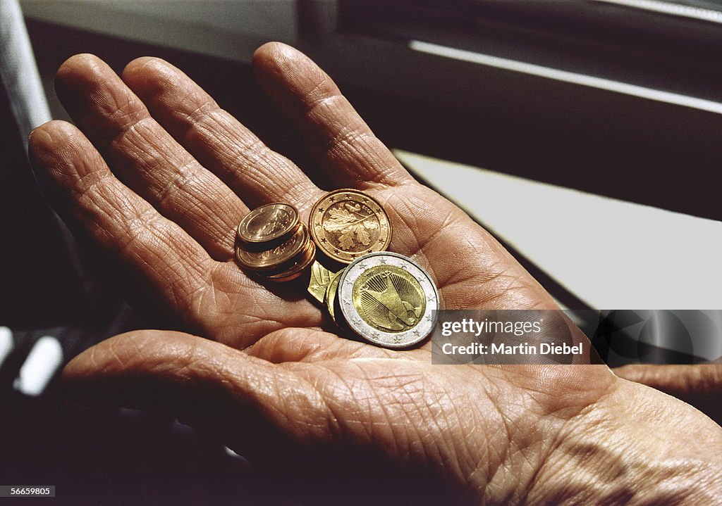 Senior woman holding Euro coins