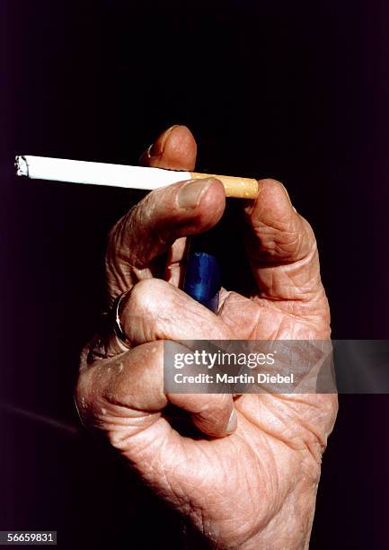 senior man holding a cigarette - old cigarette lighters stock pictures, royalty-free photos & images