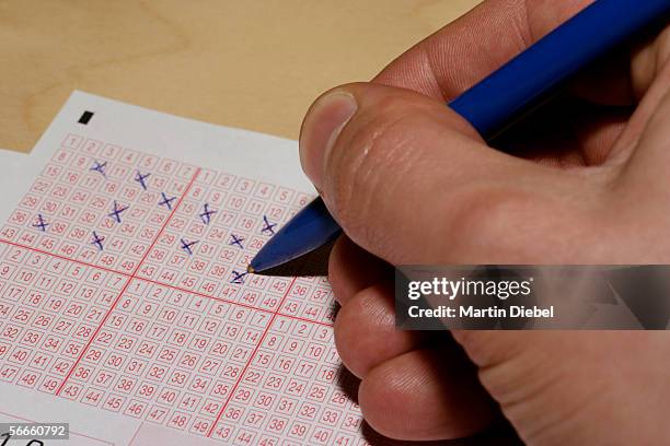 a person filling out a lottery ticket - loterij-kansspel stockfoto's en -beelden