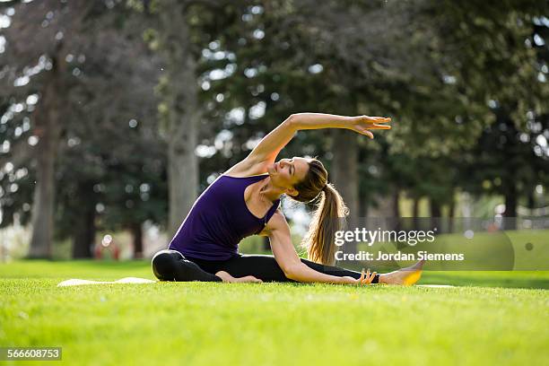 a woman doing yoga in a park. - bozeman stockfoto's en -beelden