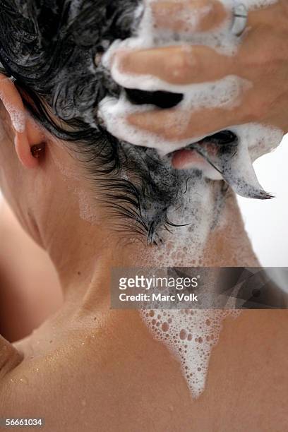 a woman washing her hair, rear view - femme shampoing photos et images de collection