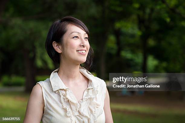 portrait of a woman smiling - japanese woman looking up stock-fotos und bilder