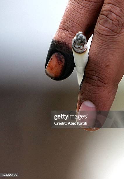 Palestinian man holds a cigarette with his inked finger, proving that he has voted, at a polling station in the U.N. School Alef which is being used...