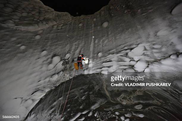 Picture taken on November 8, 2014 shows a scientist exploring a crater on the Yamal Peninsula, northern Siberia. Russian scientists have now...