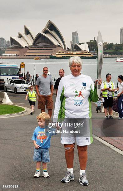 Olympic and Commonwealth gold medal swimmer Dawn Fraser is pictured in front of the Sydney Opera House with the Queen''s Baton and her grandson. The...