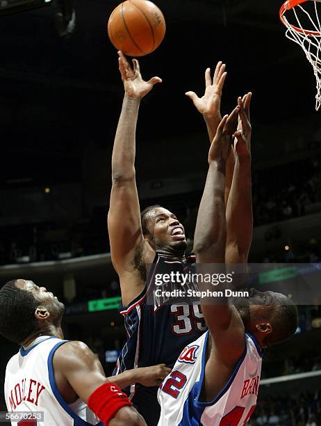 Jason Collins of the New Jersey Nets shoots over Elton Brand and Cutino Mobley of the Los Angeles Clippers on January 25, 2006 at Staples Center in...