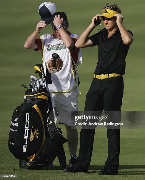 Ian Poulter of England waits on the 15th hole as his caddie Mick Donaghy looks on during the first round of The Commercial Bank Qatar Masters at Doha...