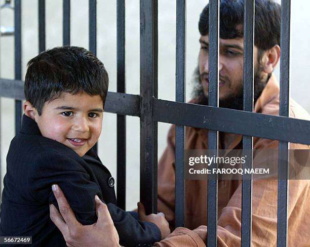 Pakistani prisoner Zulfiqar facing murder charges reaches through the bars of his cell to greet a child relative at Adyala Jail in Rawalpindi, 26...