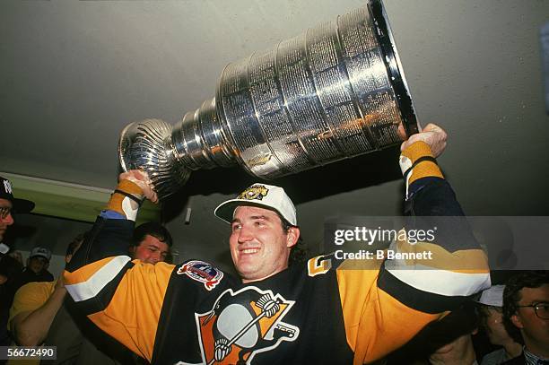 Canadian professional hockey player Mario Lemieux, forward for the Pittsburgh Penguins, hoists the Stanley Cup over his head as the Pens celebrate...