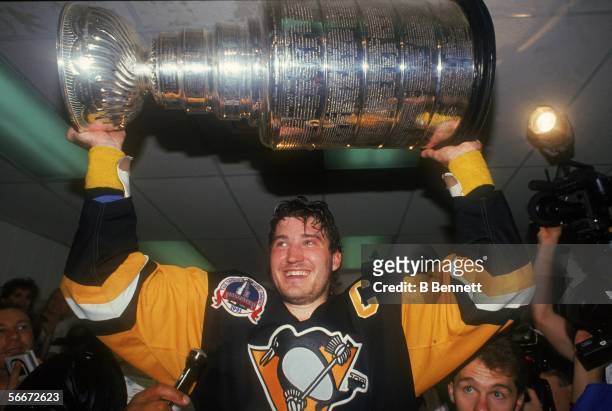 Canadian profession hockey player Mario Lemieux of the Pittsburgh Penguins hoists the Stanley Cup over his head as he celebrates the Pens' first...