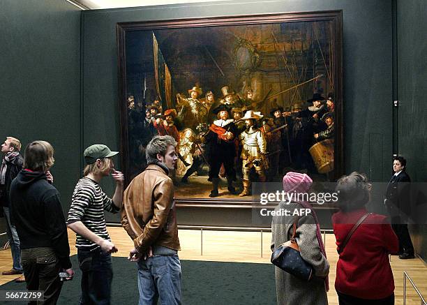 Amsterdam, NETHERLANDS: Visitors look at Dutch artist Rembrandt van Rijn's famous "Night Watch" painting in Amsterdam's Rijskmuseum, 26 January 2006....