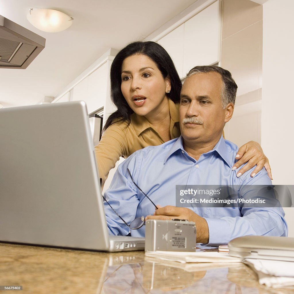 Low angle view of a mature couple in front of a laptop