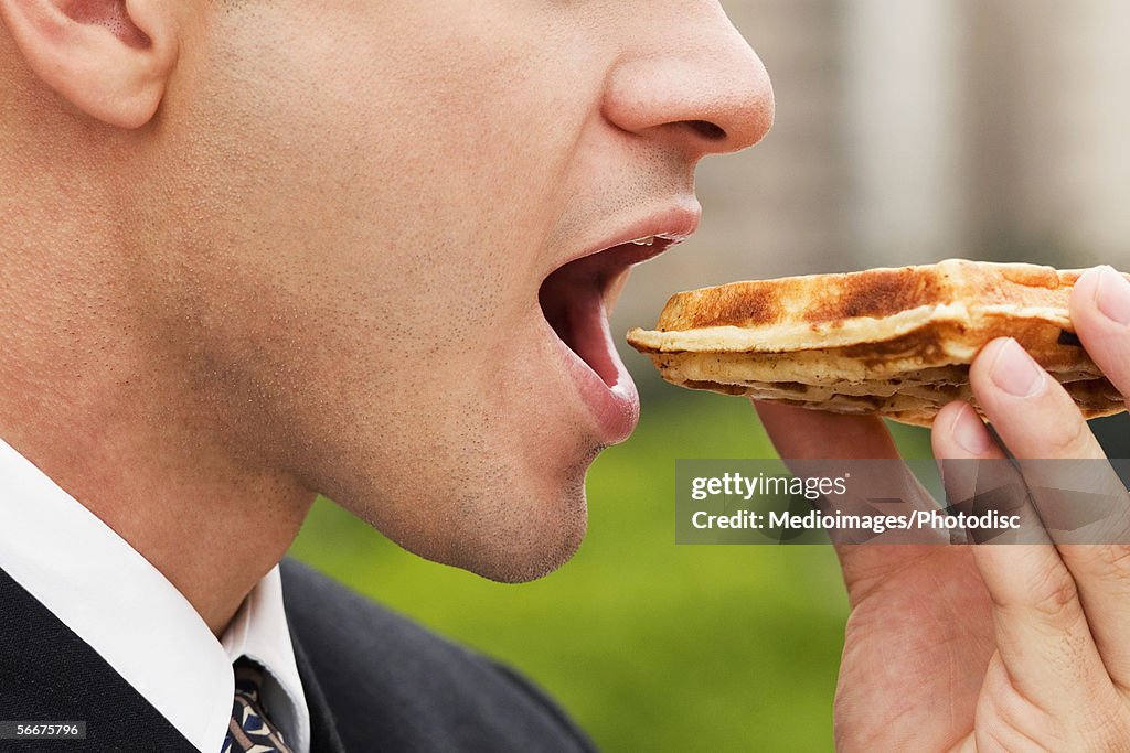 Close-up of a businessman eating a slice of pizza