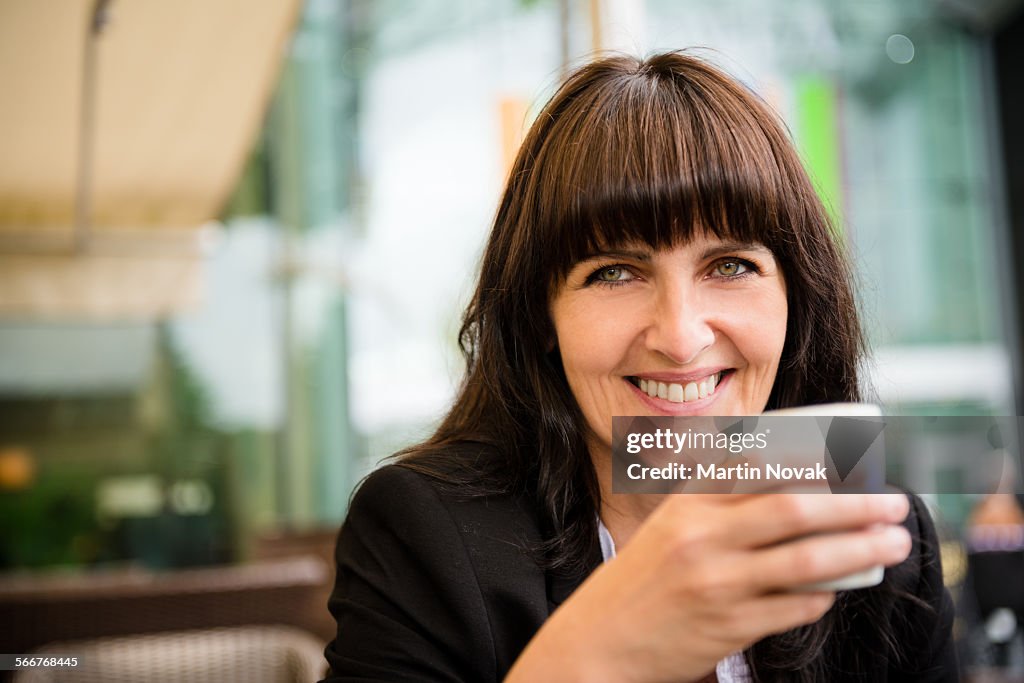 Senior business woman drinking coffee outdoor