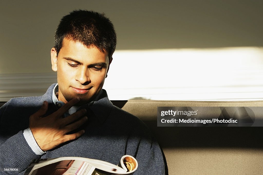 Close-up of a young man reading a magazine