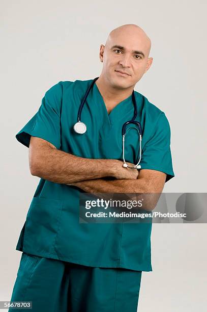 portrait of a male surgeon standing with his arms crossed - ethnicity stock pictures, royalty-free photos & images