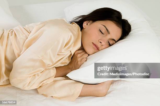 young woman sleeping on a bed - man sleeping pillow stock-fotos und bilder