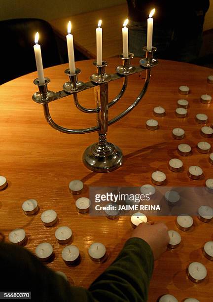 Spain: A woman lights a candle during a ceremony in Palma de Mallorca's synagogue, 26 January 2006 on the eve of Holocaust memorial day. The UN...