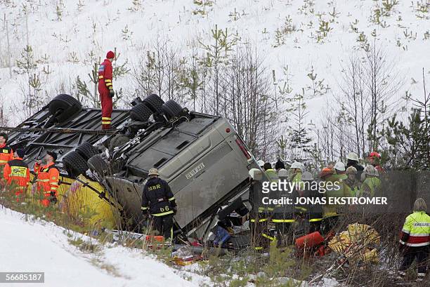 Rescue personnel work at the site of a bus accident at a highway near Arboga, some 100 kilometers west of Stockholm 27 January 2006. Several people...