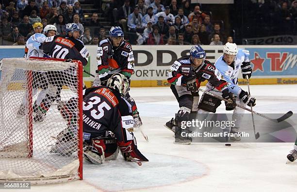 Jeff Ulmer of Hamburg slips the puck past Rainer Suchen of Ausburg to score the third goal during the DEL Bundesliga game between Hamburg Freezers...