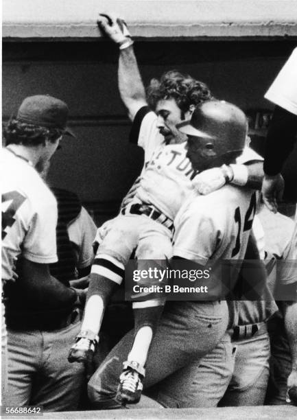 American professional baseball player Jim Rice , left fielder for the Boston Red Sox, carries injured teammate and second baseman Jerry Remy into the...