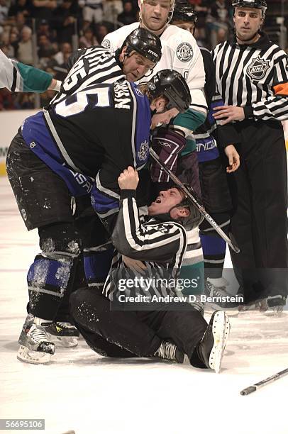 Jeff Cowan of the Los Angeles Kings helps linesman Pat Dapuzzo up off the ice after he tried to separate Cowan and Todd Fedoruk of the Anaheim Mighty...