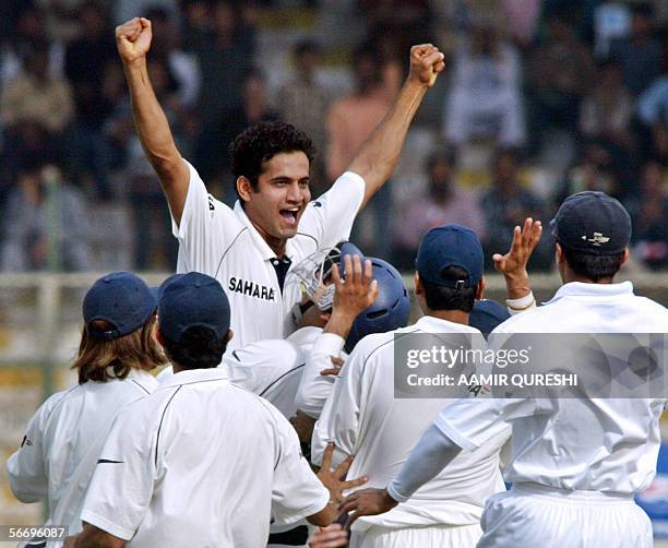 Indian cricketer Irfan Pathan raises his hands in the air as he celebrates with teammates after raking a hat-trick with the wicket of unseen...