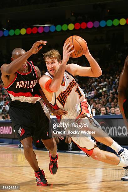 Troy Murphy of the Golden State Warriors drives to the basket against Travis Outlaw of the Portland Trail Blazers on January 28, 2006 at the Arena in...