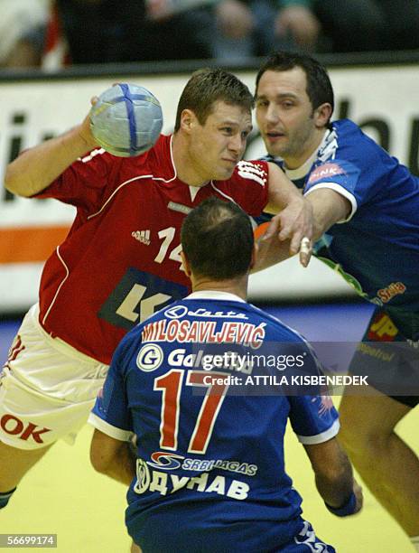 Danish Michael Knudsen is sandwiched by Serbian Alem Toskic and Zikica Milosavljevic in the local sports hall of Sursee 29 January 2006 during a...