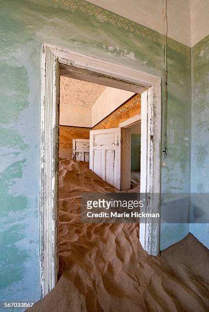 two white doors stuck in sand in abandoned house - kolmanskop stockfoto's en -beelden