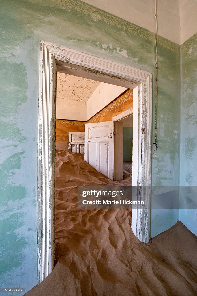 Two white doors stuck in sand in abandoned house