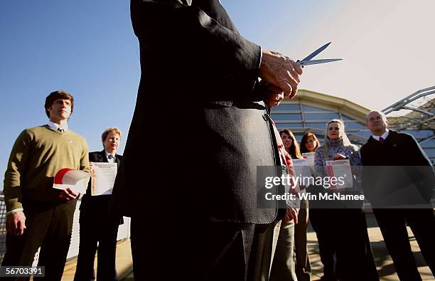 As flight attendants look on, U.S. Representative Edward Markey holds a pair of blades, one a knife, the other from a pair of scissors, at a media...