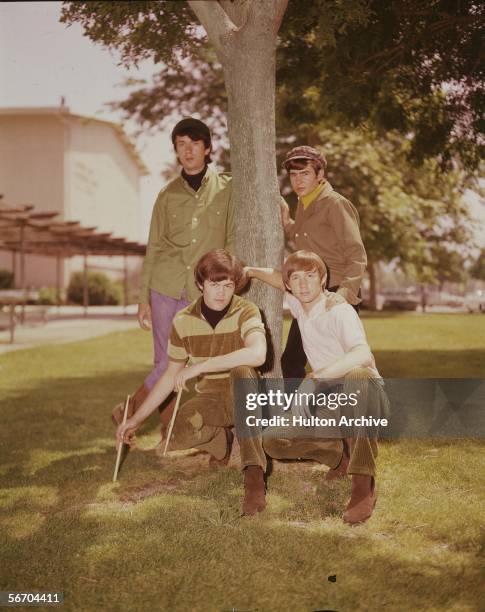 Promotional portrait of the Monkees as they pose under a tree, late 1960s. From clockwise rear left, Michael Nesmith, Davy Jones, Peter Tork, and...