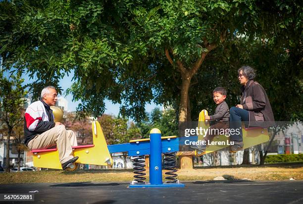 kid and grandparents playing seesaw - see saw fotografías e imágenes de stock